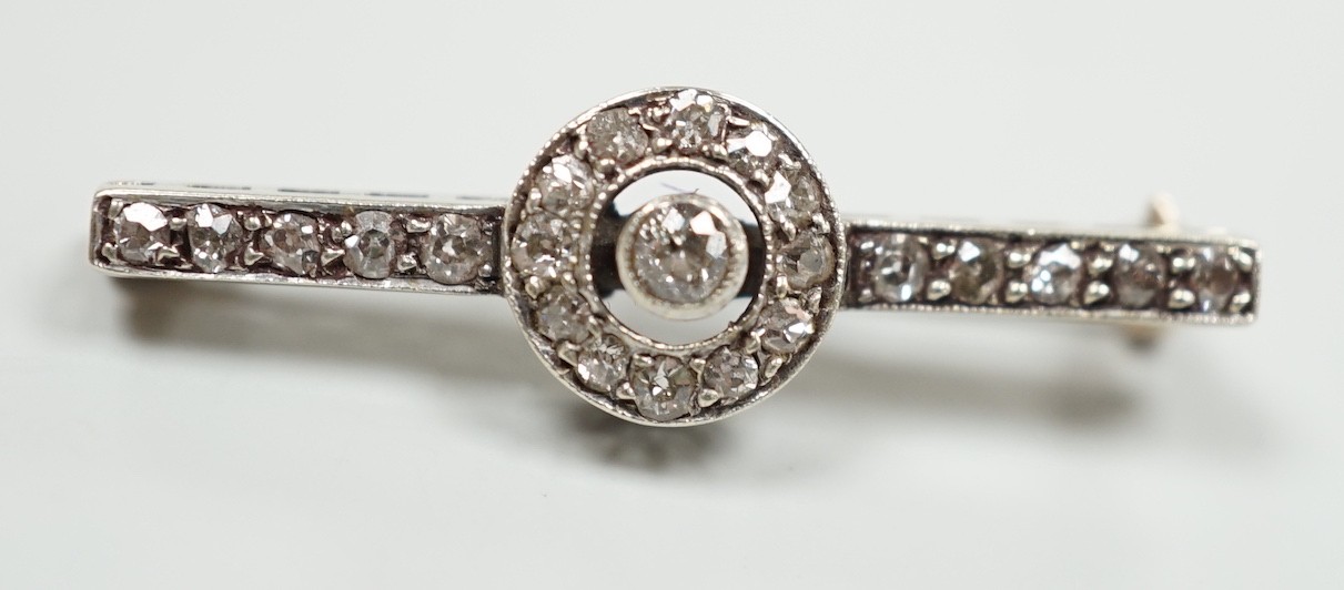 An early 20th century 9ct white metal diamond target cluster set bar brooch, 30mm, gross weight 2.5 grams.